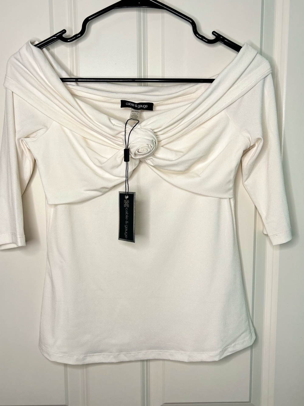 Cable & Gauge off-the-shoulder white top with a rosette detail twisted front.